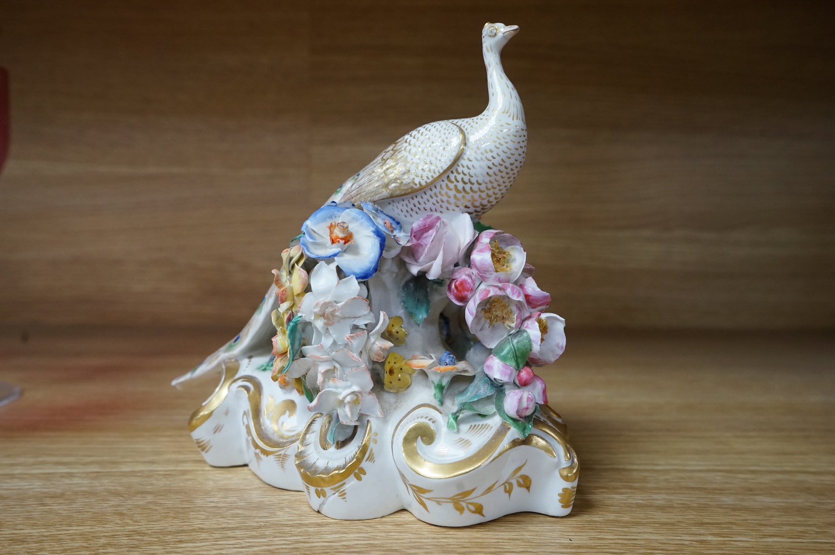 An ornate Bloor Derby peacock with floral encrusted decoration, 16cm high
